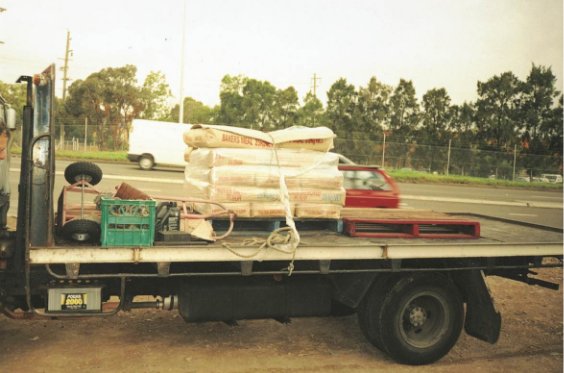 Trailer with unrestrained trolley, crate and pallet and a insufficiently restrained loaded pallet