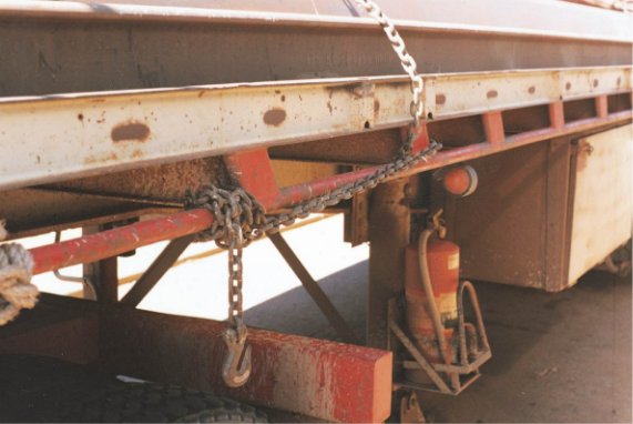 Side view of a trailer with restraint chains knotted at the end