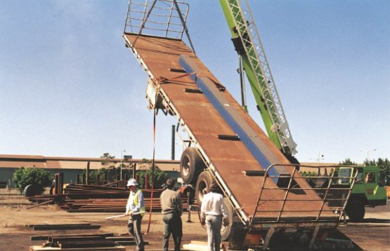 A steel trailer loaded with steel tube load tilted for tilt test