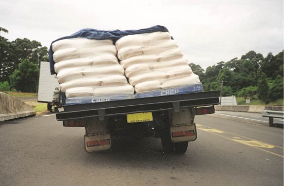 Rear photo of a truck carrying slippery bags. The bags have moved to one side of a truck causing the vehicle to be unstable.
