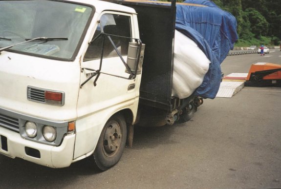 Front view of the truck with slippery bags moved to the side of the vehicle. The bags are restrained by tarpaulin only.