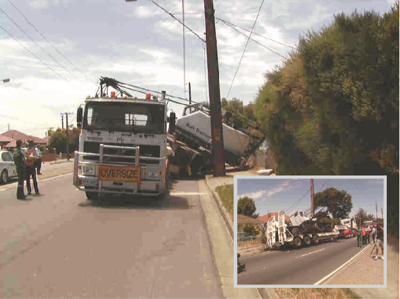 Front view of a truck with a crane dislodged from the vehicle. The crane has interfered with a electric pole.