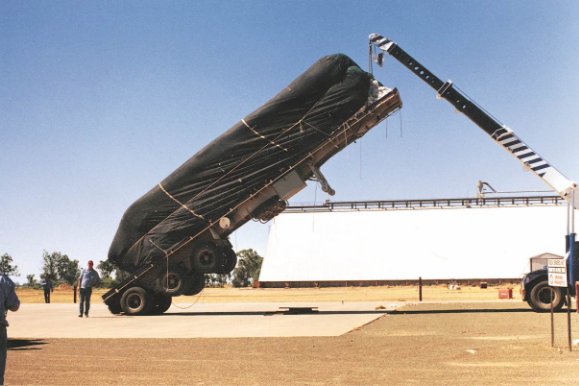 Side view of a loaded trailer tilted in the reverse direction on a testing jig