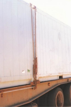 Side view of a container restrained on a flat top trailer using two chains
