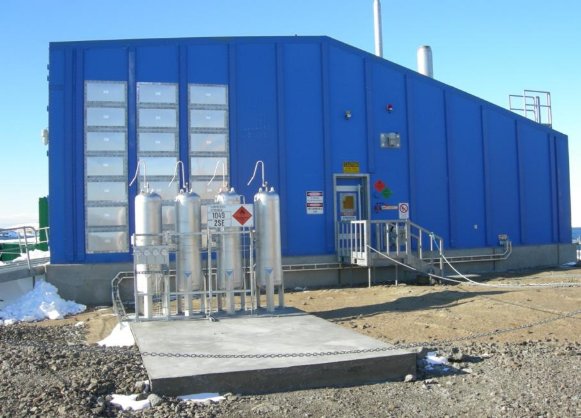 Exterior photograph of a blue coloured AANBUS-style building in 2012