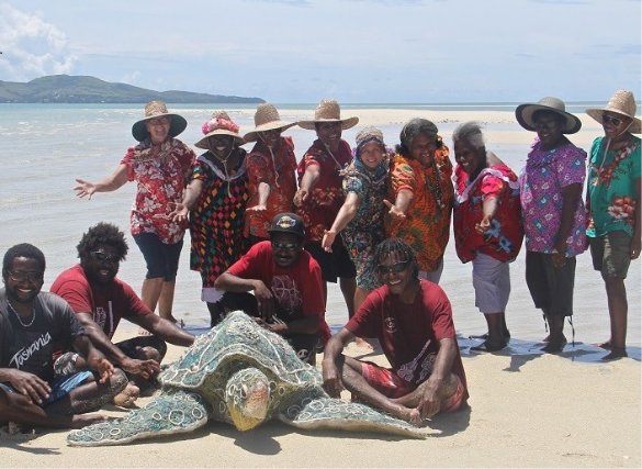The Erub Arts Ghost Net Gang at Seu Cay (eastern Torres Strait) with Emarr Totol, made from ghost net material. Image copyright of Erub Arts, photographer Lynnette Griffiths.
