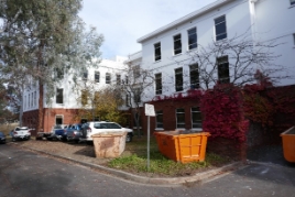 Two wings of a three storey, brick and render building.  