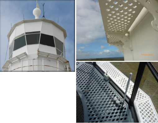 Photograph showing white lantern house and lattice external catwalk at top of lighthouse tower.