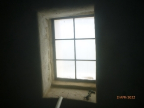 Photograph showing window fitted into stone wall.