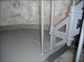 Photograph of grey half floor. Lattice staircase fixed to floor.