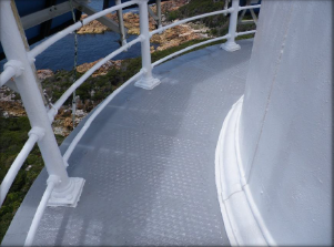 Photograph of curved balcony floor wrapping around lantern room, with balustrades fitted to outer edge of floor.