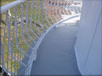 Photograph of curved balcony floor with balustrade fixed to outer edge of floor. Modern aluminium mesh is fitted to railing.