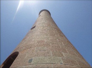 Photograph of granite lighthouse tower taken from the base.