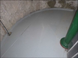 Photograph of curved plate landing floor. A green column is fitted on top of floor.