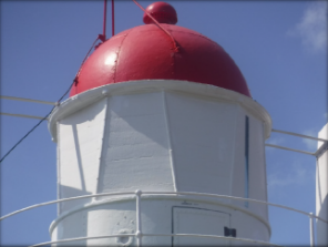 Photograph showing circular lantern house with red dome fitted on top.  