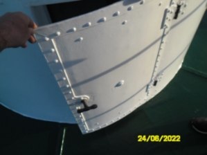 Photograph showing curved lantern house door standing slightly ajar. 
