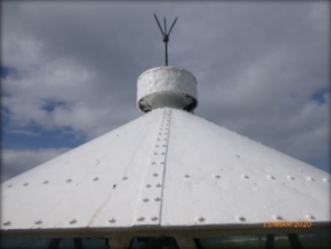 Photograph showing conical white lantern roof with ventilator at top.