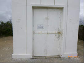 Photograph showing double framed and sheeted doors at base of lighthouse tower. 