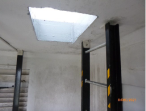 Photograph showing a ladder fixed to underside of the lantern room beside a small floor hatch leading to the level above.