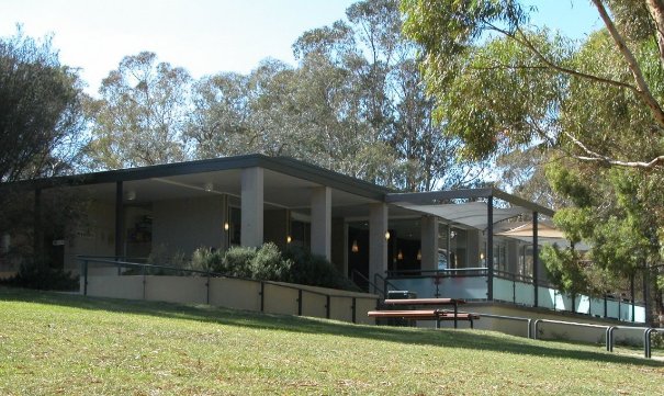 The former 'Outpost Cafe' surronded by green grass and tress, shortly before its demolition.