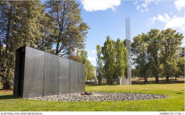 For Our Country Sculpture, Dark grey / black Glass enclosure with a circle rock pit in front of the sculpture.