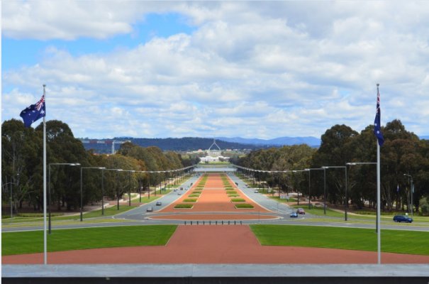 View from the front steps of the memorial building down Anzac Parade where new and old Parliment House can be seen at the end of the parade across Lake Burley Griffin.