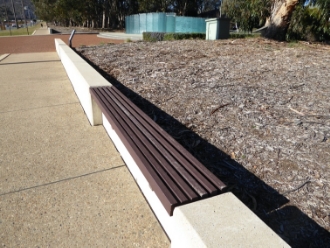 Typical concrete wall and timber seat on Anzac Parade with the Australian Service Nurses National Memorial in the background
