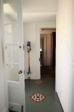 A continuation image of the stairwell which shows the door to its landing which is white with large square window panels 