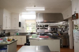 A picture of a kitchen in Kirribilli House with steel appliances and steel countertops.