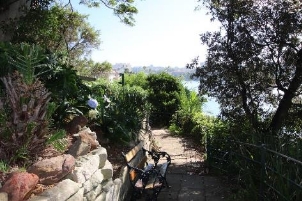 A picture overlooking a path with trees and stone walls along its side. 