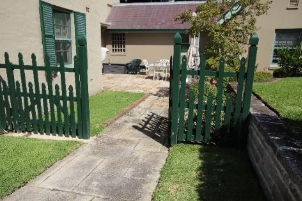 A picture of a side gate at Kirribilli House and a concrete path to guide from the front and back end of the property.
