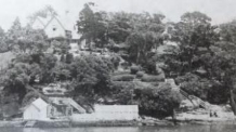 A black and white picture of the Kirribilli House boat house from the harbour