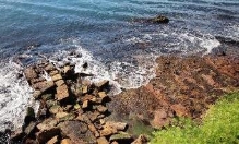 A picture of the boar harbour surrounded by large rocks and waves of water from the harbour