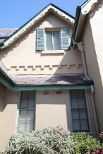 A picture of Kirribilli House windows with green framing and shutters 