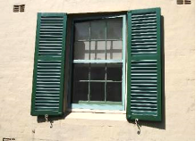 A picture of a Kirribilli House window with the green framing and shutters open
