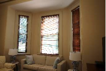 A picture of the Kirribilli House green room with white furniture and fittings and brown wood shutters on the windows 