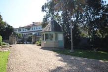 A picture of the Kirribilli House guard house showing a cone shaped roof and green framed windows 