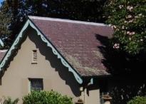 A picture of a Kirribilli House, dark red stained slated roof