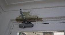 A picture of brown splotches from peeled paint above a door way 