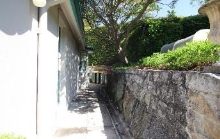 A picture of a narrow walk way between Kirribilli House and a stone wall adjacent