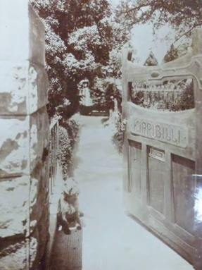 A black and white of a gate which says Kirribilli on its front 