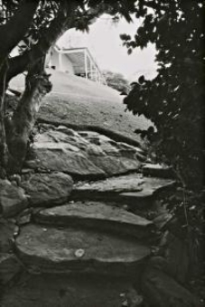 A black and white picture of large stone steps leading up to the Kirribilli House from its sloped garden