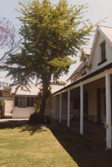 A picture of columns and a large tree to the side of Kirribilli House