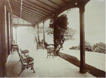 A sepia tone image of the Kirribilli House veranda showing the outdoor furniture and columns before the lawn