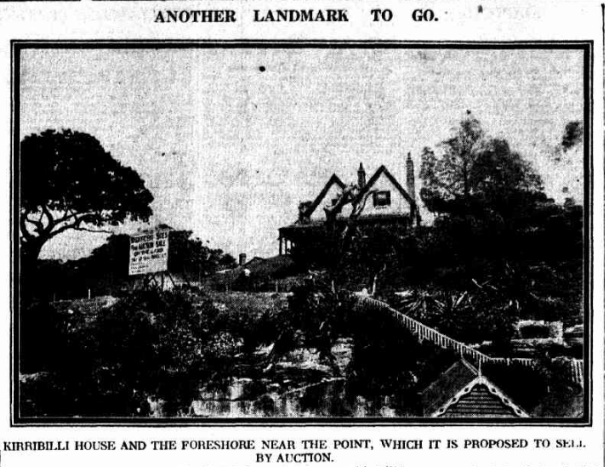 A black and white image of Kirribilli House from the harbour overlooking the cliff, trees, the house and its grounds. 