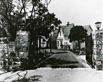 A black and white picture of the Kirribilli House entry gates opened allowing access to the main entry and house