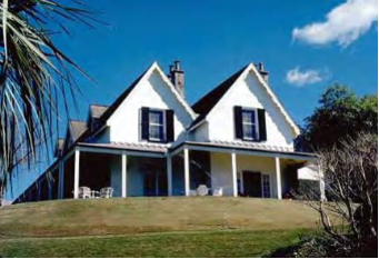 A picture of Kirribilli House from the garden showing the property, grass lawns and surrounding trees